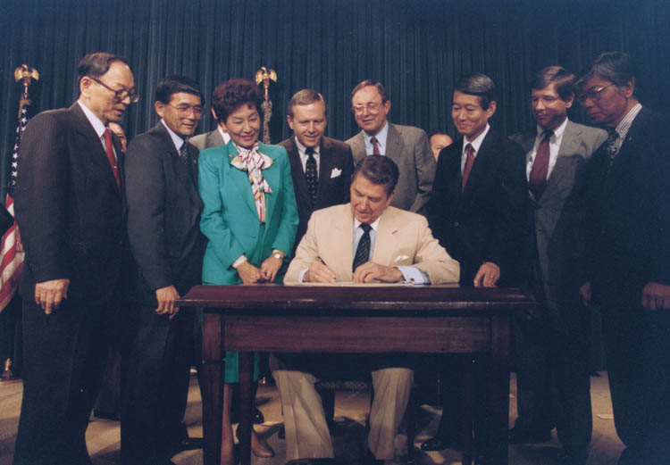 Ronald_Reagan_signing_Japanese_reparations_bill.jpg
